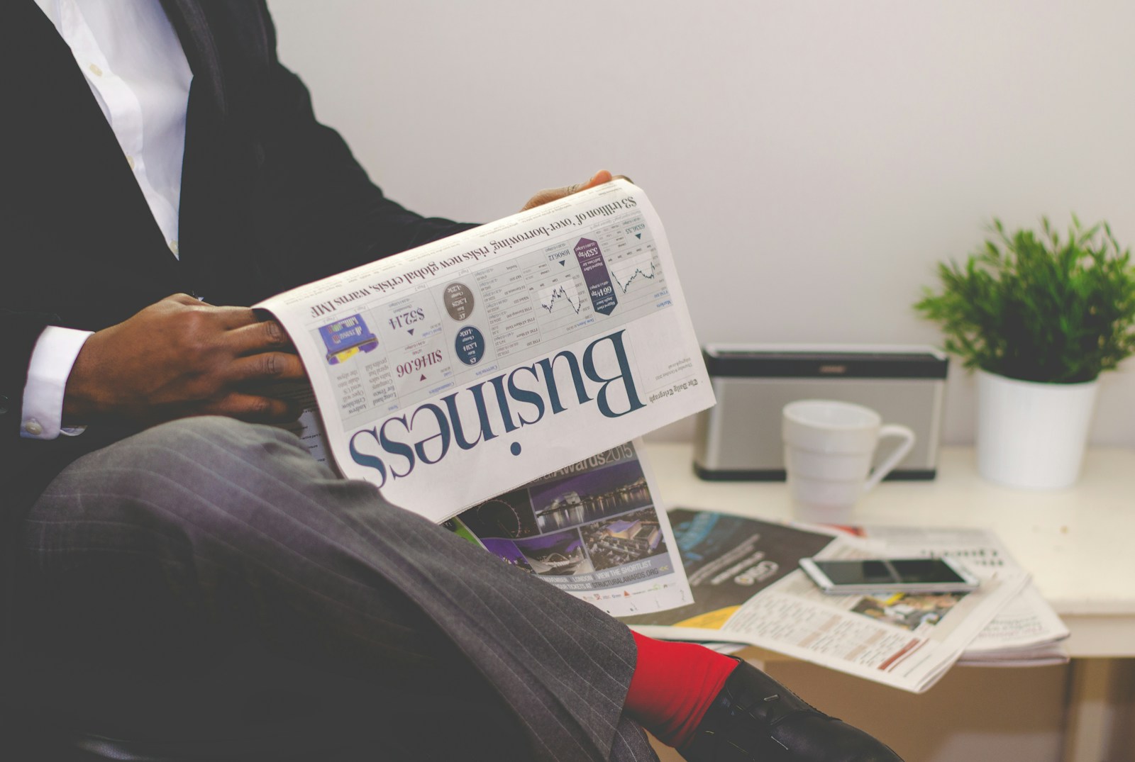 Photo by Adeolu Eletu person sitting near table holding newspaper